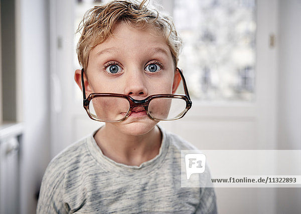 Porträt eines verspielten Jungen mit übergroßer Brille