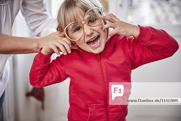 Porträt eines verspielten Mädchens mit übergroßer Brille