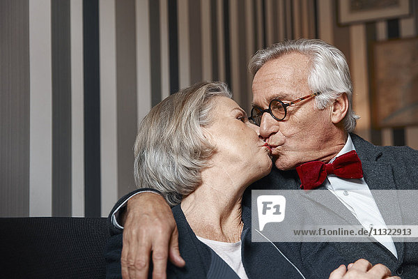 Senior couple kissing on couch