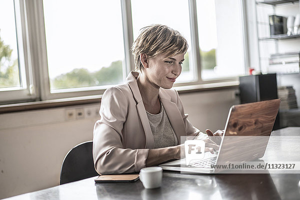 Geschäftsfrau mit Laptop im Konferenzraum