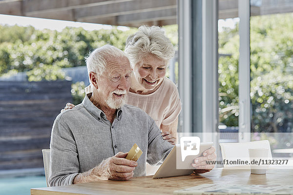 Seniorenpaar bei der Online-Zahlung mit Kreditkarte