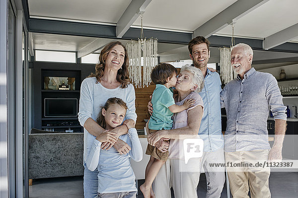 Mehrgenerationen-Familie steht im Einfamilienhaus