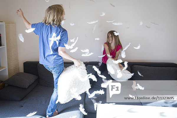 Pillow fight between brother and sister at home