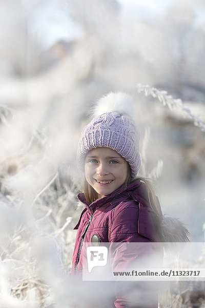 Portrait of happy girl wearing bobble hat in winter