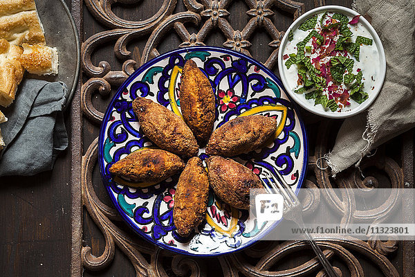 Kibbeh  orientalische Fleischkroketten mit Joghurtsauce auf dem Teller