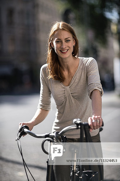 Porträt einer rothaarigen Frau mit Fahrrad