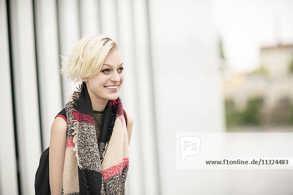 Porträt einer lächelnden blonden Frau mit Schal