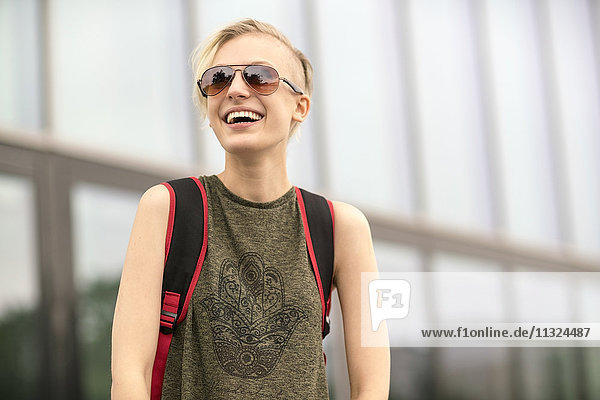 Porträt der lachenden blonden Frau mit Sonnenbrille