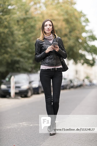 Junge Frau auf der Straße mit Smartphone