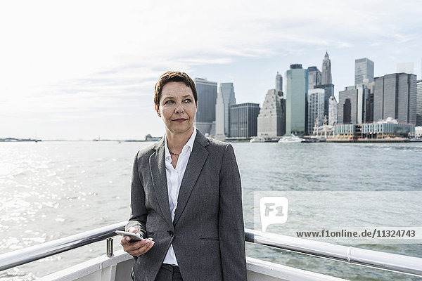 USA  Brooklyn  portrait of pensive businesswoman standing on boat