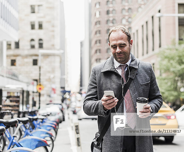 USA  New York City  businessman on the move in Manhattan looking on cell phone