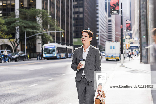 USA  New York City  businesswoman in Manhattan with takeaway coffee