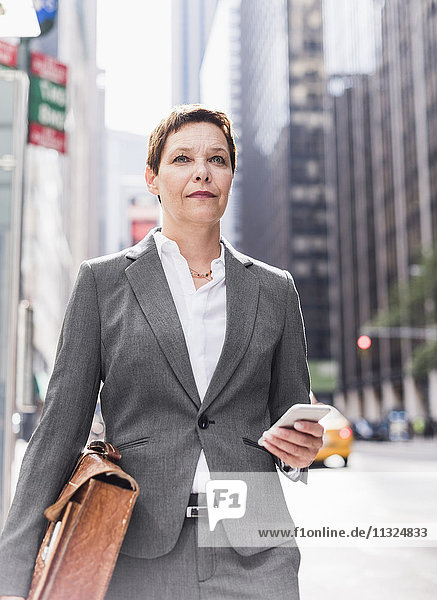 USA  New York City  Geschäftsfrau in Manhattan mit Handy