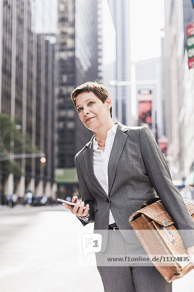 USA  New York City  businesswoman in Manhattan with cell phone
