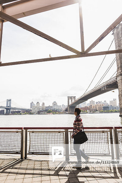 USA  New York City  Frau beim Spaziergang am East River