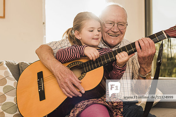 Großvater und Enkelin beim gemeinsamen Gitarrespielen