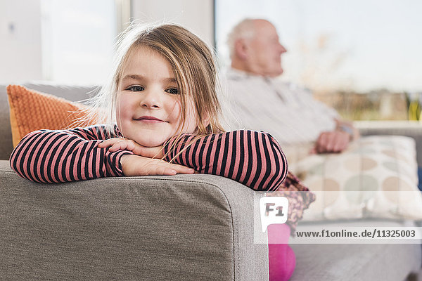 Kleines Mädchen sitzend auf der Couch mit ihrem Großvater