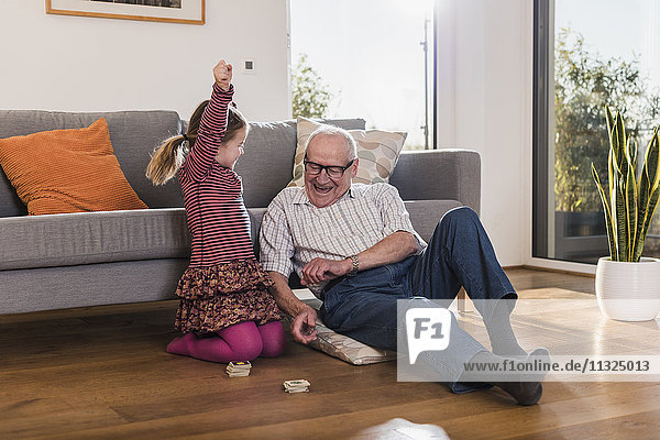 Großvater und Enkelin spielen Erinnerung  Mädchen feiert Sieg