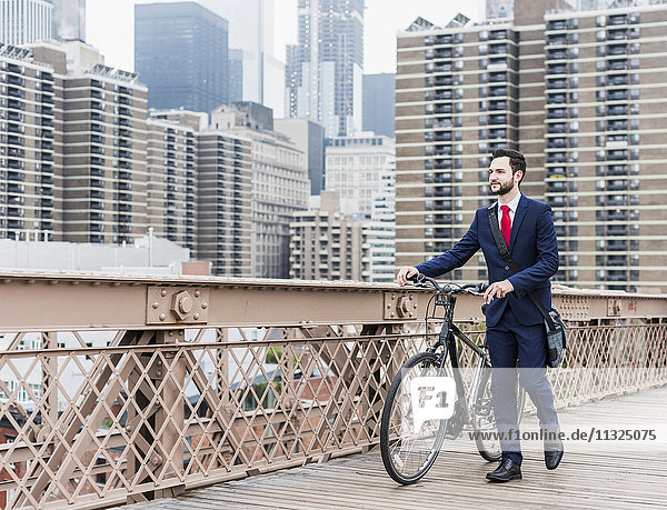 USA  New York City  Geschäftsmann mit Fahrrad auf der Brooklyn Bridge