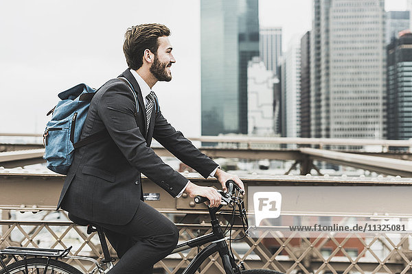 USA  New York City  Geschäftsmann auf dem Fahrrad auf der Brooklyn Bridge
