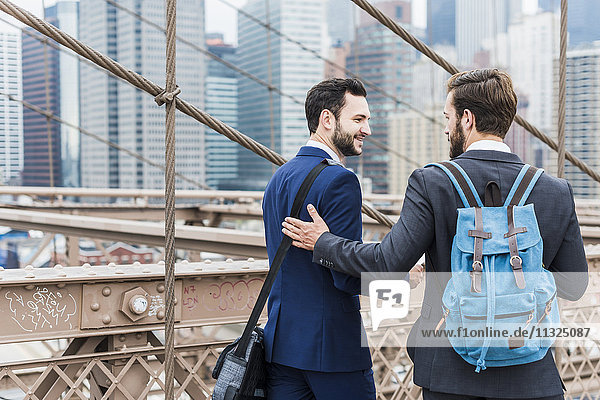 USA,  New York City,  zwei Geschäftsleute an der Brooklyn Bridge
