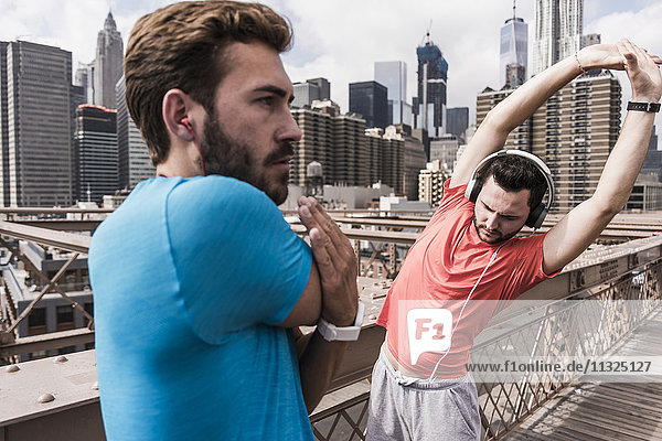 USA New York City two athletes stretching on Brooklyn Brige