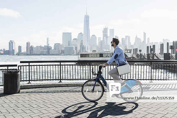 USA  man on bicycle at New Jersey waterfront with view to Manhattan