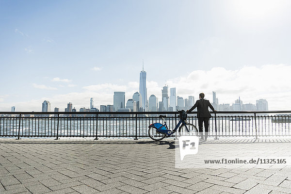 USA  Mann mit Fahrrad am New Jersey Waterfront mit Blick nach Manhattan