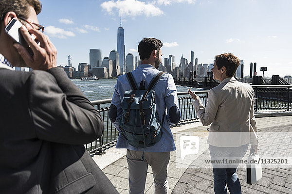 USA  colleagues walking at New Jersey waterfront with view to Manhattan