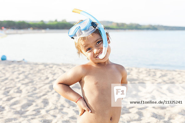 Portrait of little boy with diving goggles and snorkel on the beach