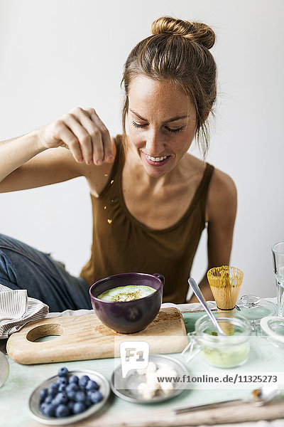 Frau bereitet Matcha Latte zu Hause vor