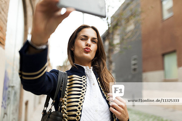 Fashionable young woman taking a selfie