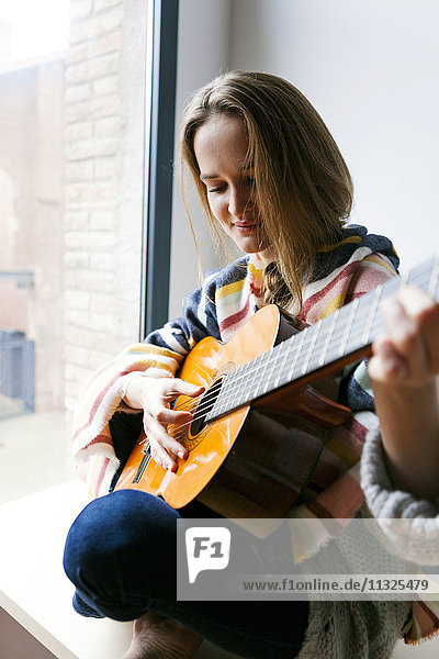 Junge Frau spielt Gitarre