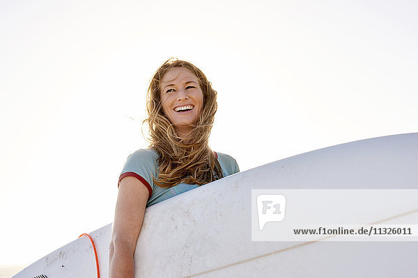 Glückliche Frau mit Surfbrett