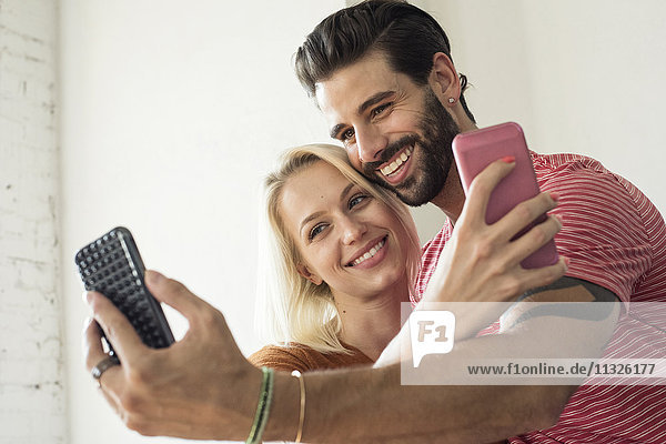 Ein glückliches junges Paar nimmt einen Selfie.