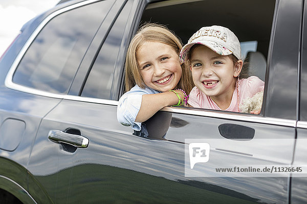 Girls sitting in car  looking out of window