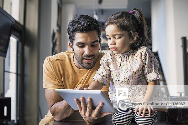 Vater und Tochter mit digitalem Tablett