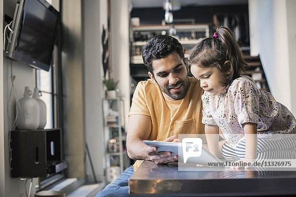 Vater und Tochter mit digitalem Tablett