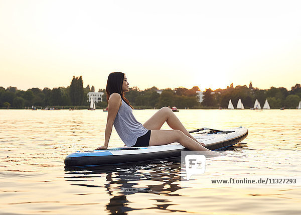 Germany  Hamburg  Young woman on paddleboard enjoying summer