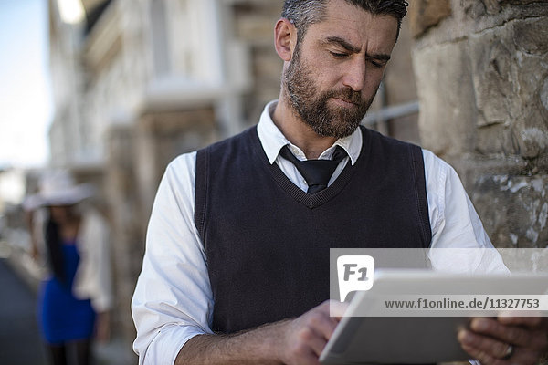 Man using tablet outdoors
