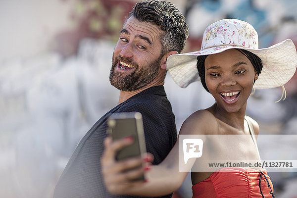 Glücklicher Mann und Frau  die ein Selfie mit Handy nehmen