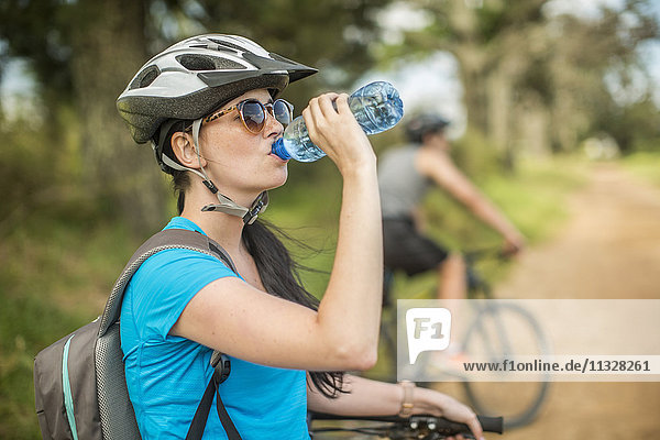 Young couple mountainbiking in nature  woman drinking water