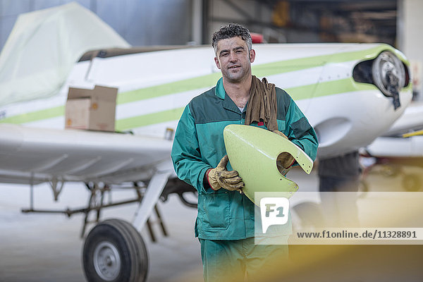 Mechanic in hangar repairing light aircraft