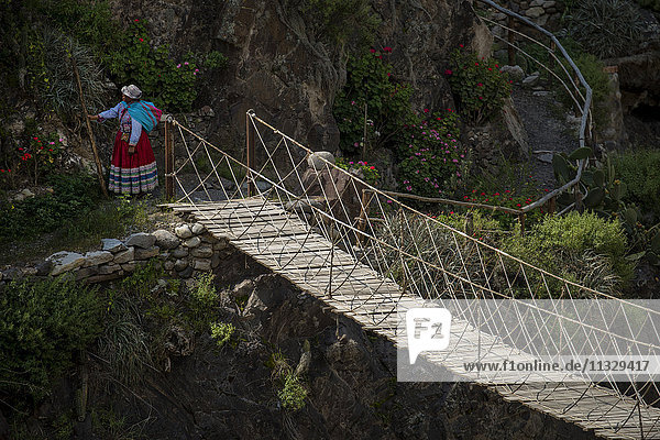 Frau auf Drehbrücke im Colca Canyon in Peru