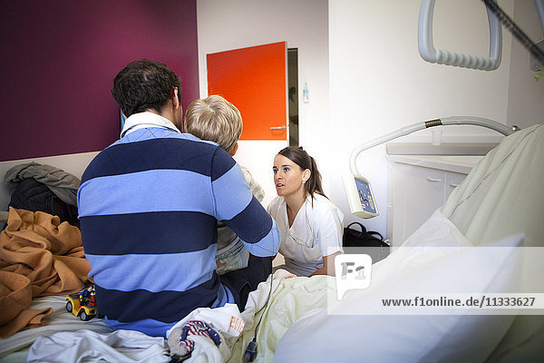 Reportage aus der pädiatrischen Notaufnahme eines Krankenhauses in Haute-Savoie  Frankreich. Eine Krankenschwester spricht mit dem Vater eines jungen Patienten in der Kurzzeit-Notfallstation.