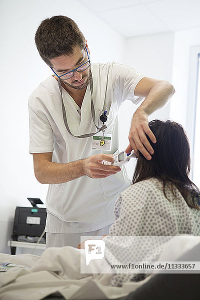 Reportage aus der pädiatrischen Notaufnahme eines Krankenhauses in Haute-Savoie  Frankreich. Eine Krankenschwester misst die Temperatur eines jungen Mädchens.