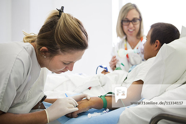 Reportage aus der pädiatrischen Abteilung eines Krankenhauses in Haute-Savoie  Frankreich. Eine Krankenschwester legt einen Katheter  während eine andere eine Maske hält  die Nitronox (eine Mischung aus Gas und Luft) freisetzt.
