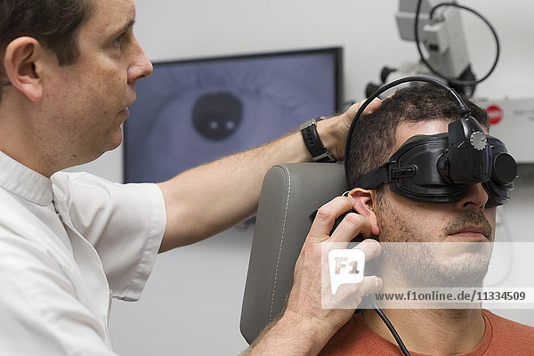 Reportage über einen HNO-Arzt in Nizza  Frankreich  der Patienten behandelt  die unter Schwindelgefühlen leiden. Ein 37-jähriger Patient während eines Vibrationstests. Bei diesem Test wird eine Vibrationsquelle hinter dem Ohr auf den Schädel aufgebracht  um die Auswirkungen auf die Stabilität der Augenbewegungen (Nystagmus) zu analysieren.