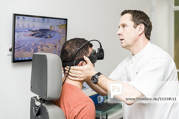 Reportage on an ENT doctor in Nice  France  treating patients suffering from dizziness. A 37-year old patient during a videonystagmoscopy test. Using a videonystagmoscopy mask that films the eye using infrared  an analysis of the stability of eye movement is carried out  looking for a nystagmus. If the test reveals unstable eye movement in various conditions  this will provide vital information on the origin of the symptoms of dizziness.