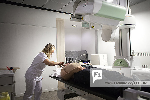 Reportage in a radiology centre in Haute-Savoie  France. A technician prepares a patient for an arthography of the shoulder.